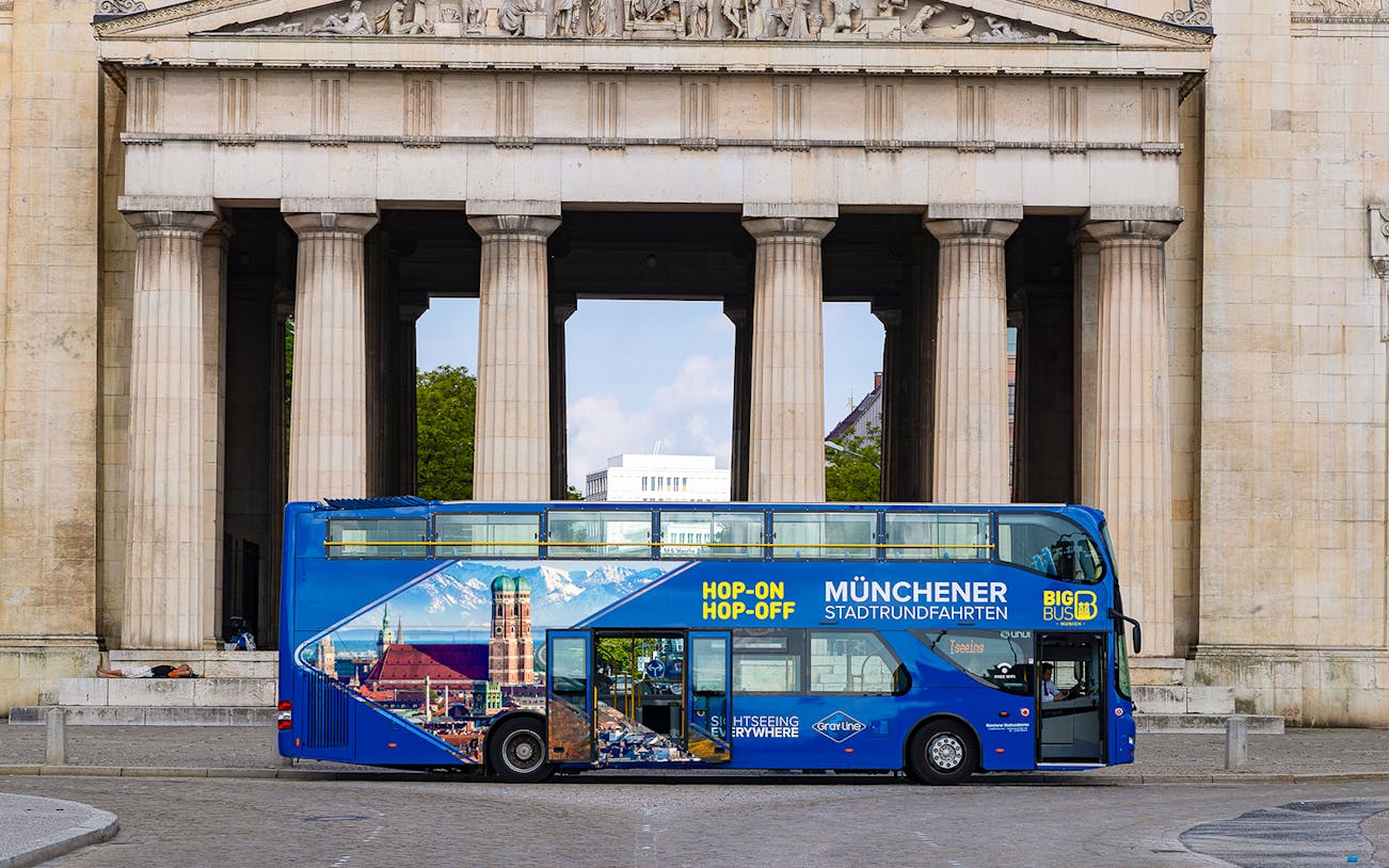 Hop-On Hop-Off bus in front of Munich landmark on tour route.