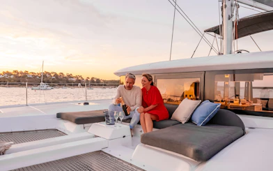 Couple enjoying champagne on a Heraklion catamaran cruise at sunset.