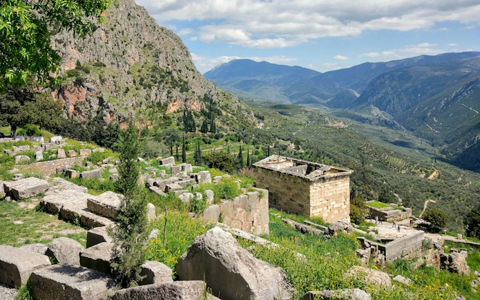 Ancient ruins at Delphi with mountainous landscape, Greece, on a guided tour from Athens.