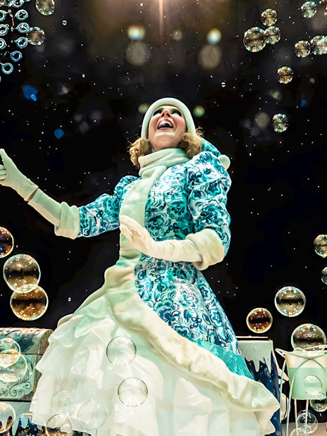 Performer creating bubbles at PortAventura's Bubble Magic Christmas show.
