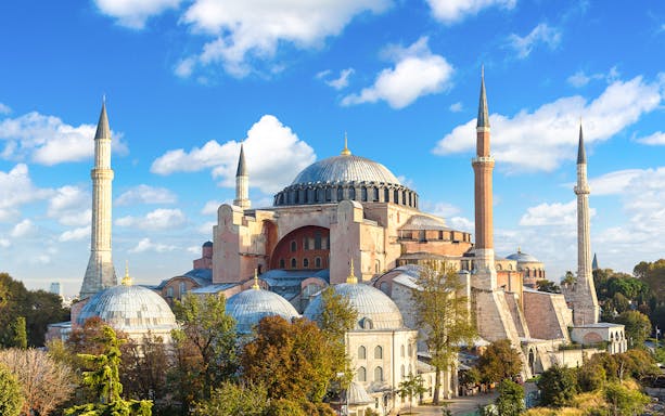 Hagia Sophia with minarets under a blue sky in Istanbul.