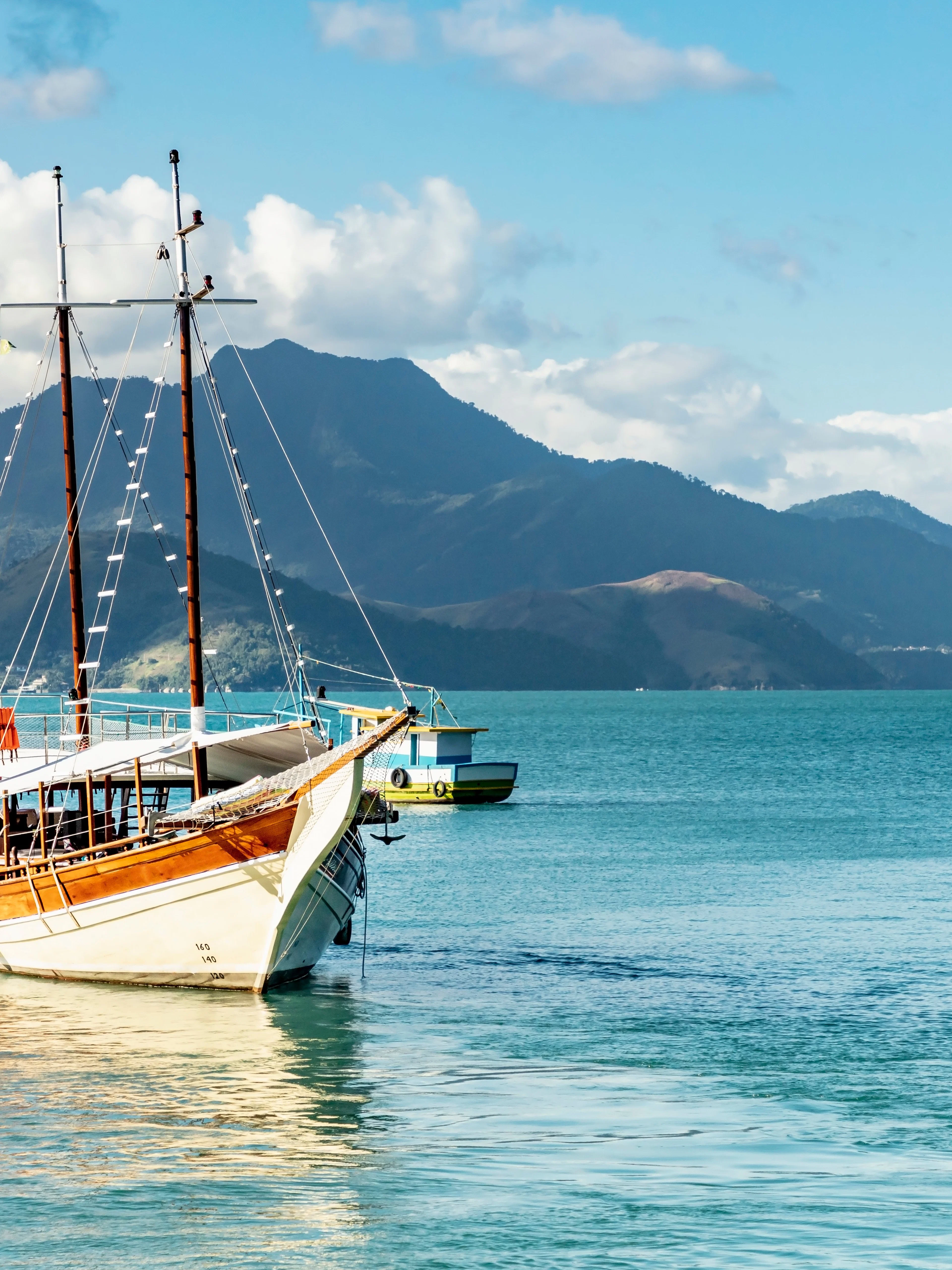 Schooner sailing in Angra dos Reis bay with Ilha Grande mountains, Rio de Janeiro, Brazil.