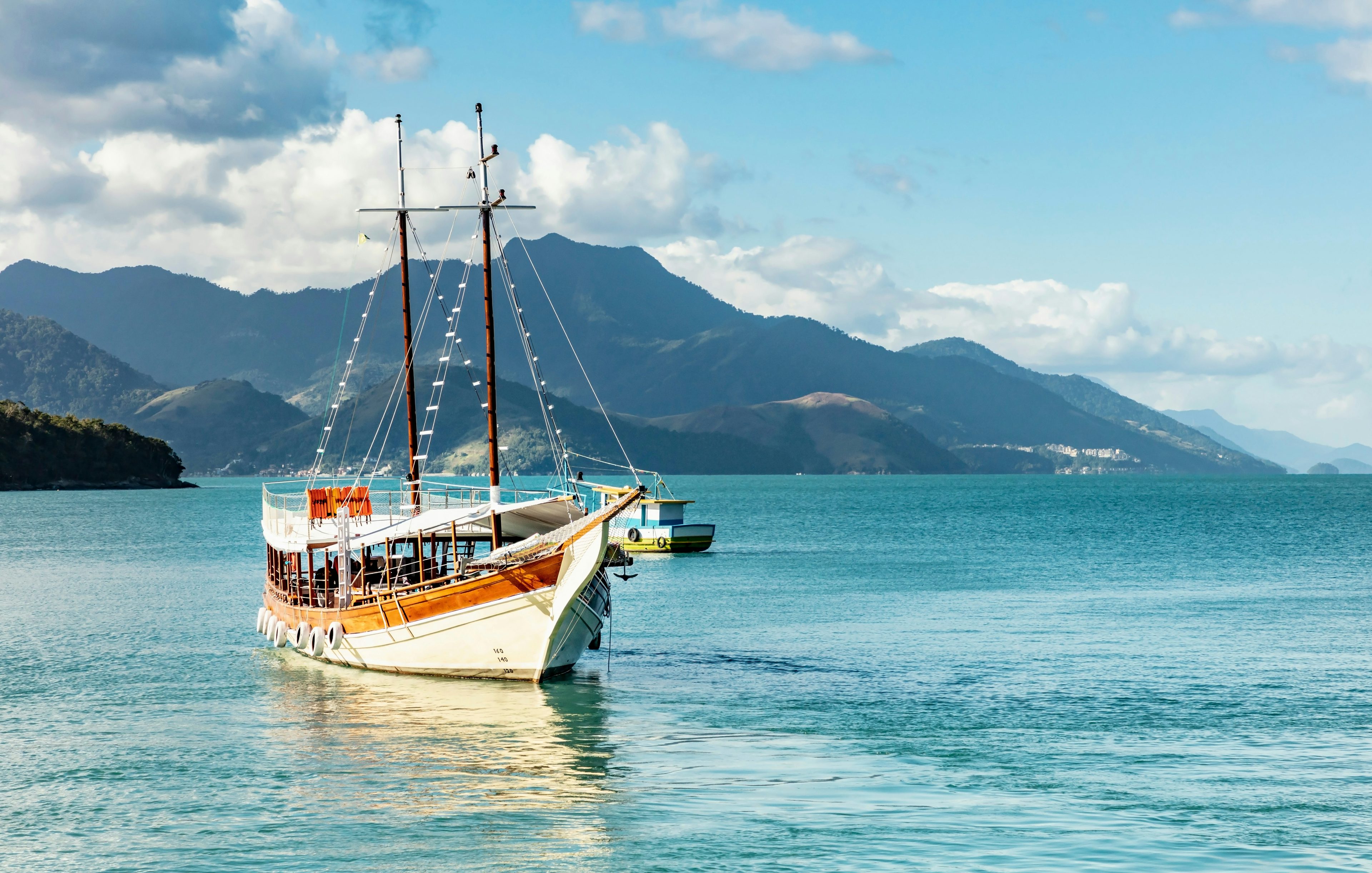 Schooner sailing in Angra dos Reis bay with Ilha Grande mountains, Rio de Janeiro, Brazil.