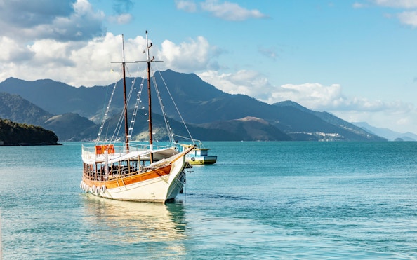 Schooner sailing in Angra dos Reis bay with Ilha Grande mountains, Rio de Janeiro, Brazil.