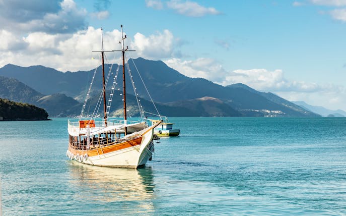 Schooner sailing in Angra dos Reis bay with Ilha Grande mountains, Rio de Janeiro, Brazil.