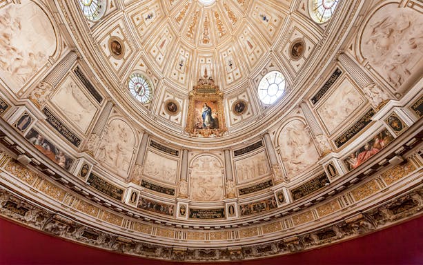 Seville Cathedral Chapter House ornate ceiling with religious artwork and intricate carvings.