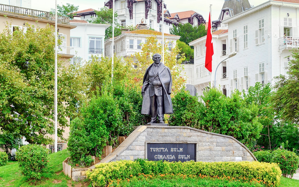 Statue of Mustafa Kemal Ataturk on Princes' Island, Turkey, with surrounding greenery.