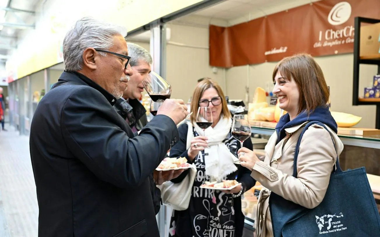 Group enjoying wine tasting at Cagliari market tour.