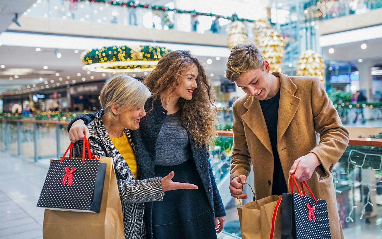 Family shopping in a Swiss mall with holiday decorations and various stores in the background.