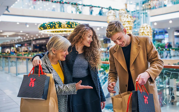 Family shopping in a Swiss mall with holiday decorations and various stores in the background.