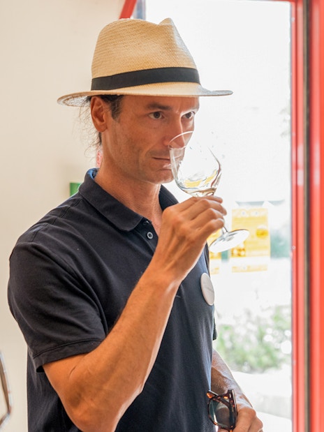 Wine tasting experience in Chateauneuf du Pape with two people sampling wine indoors.