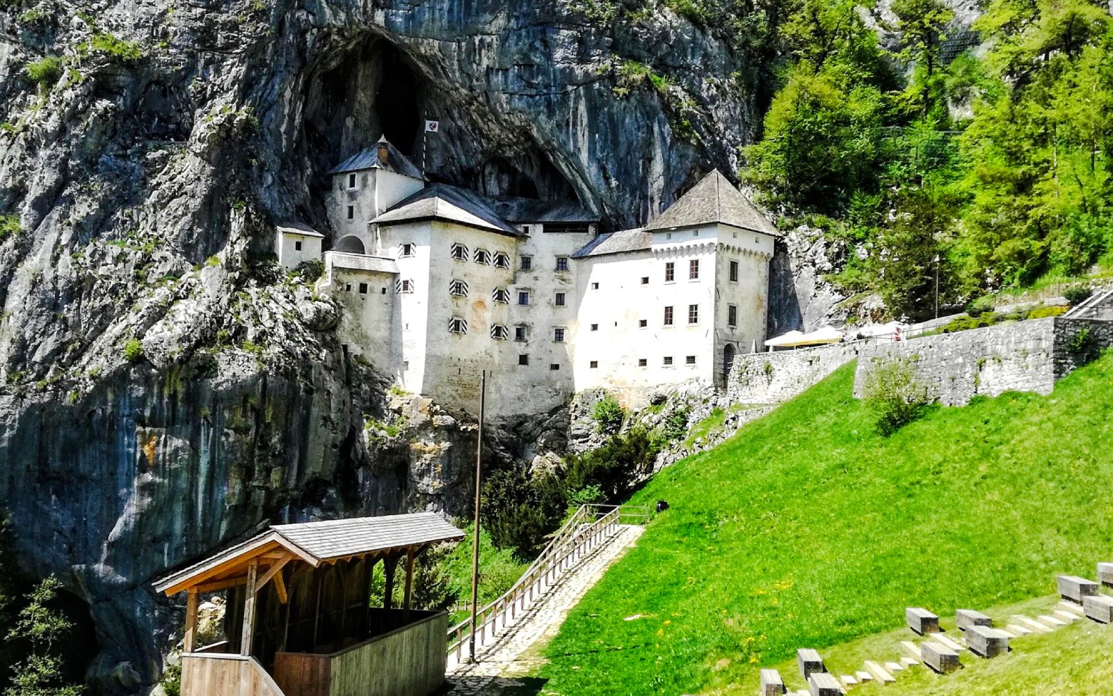 Predjama Castle nestled in a cliffside with surrounding greenery in Slovenia.