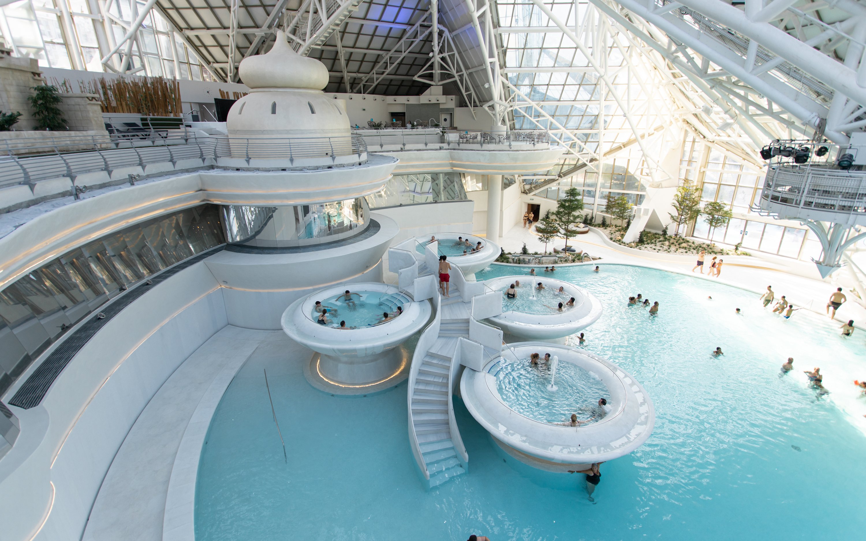 Indoor pools and hot tubs at Caldea spa resort, Andorra, with visitors enjoying the water.