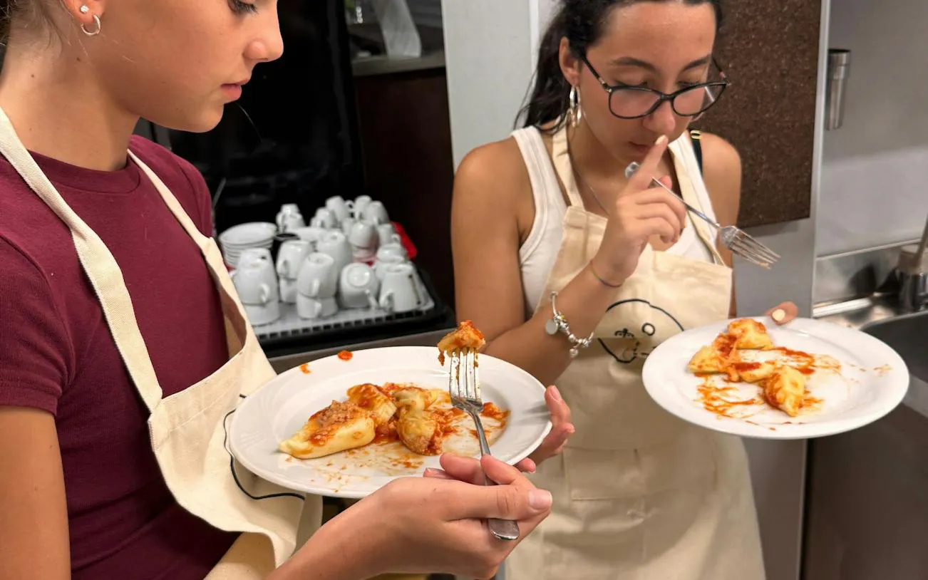 Participants tasting homemade pasta during a cooking class in Tortolì, Nuoro.