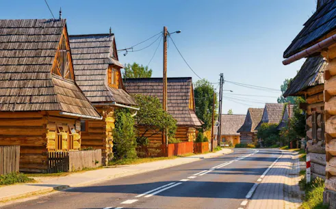 Traditional wooden houses in Zakopane along a quiet street, part of the Krakow tour.