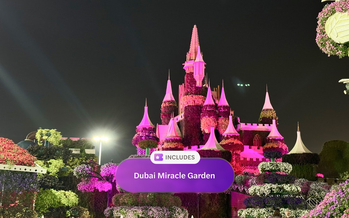 Illuminated floral castle at Dubai Miracle Garden at night.