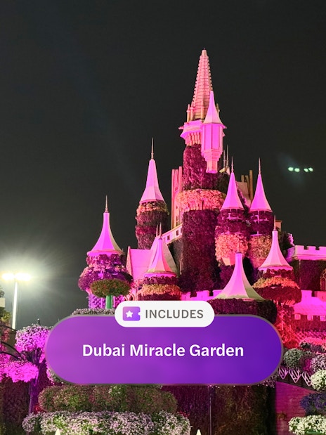 Illuminated floral castle at Dubai Miracle Garden at night.