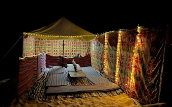 Bedouin tent with patterned walls and lights in Black and White Desert safari from Cairo.