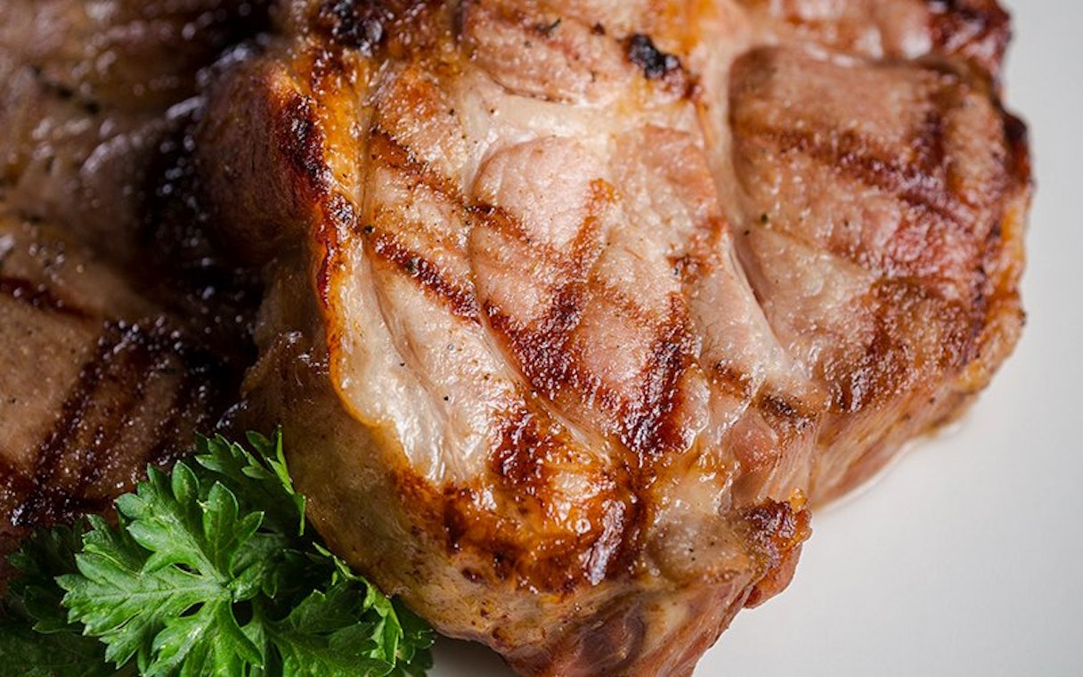 Grilled pork chops with parsley served at Aljibe Tango Show.