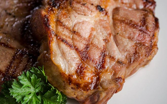 Grilled pork chops with parsley served at Aljibe Tango Show.