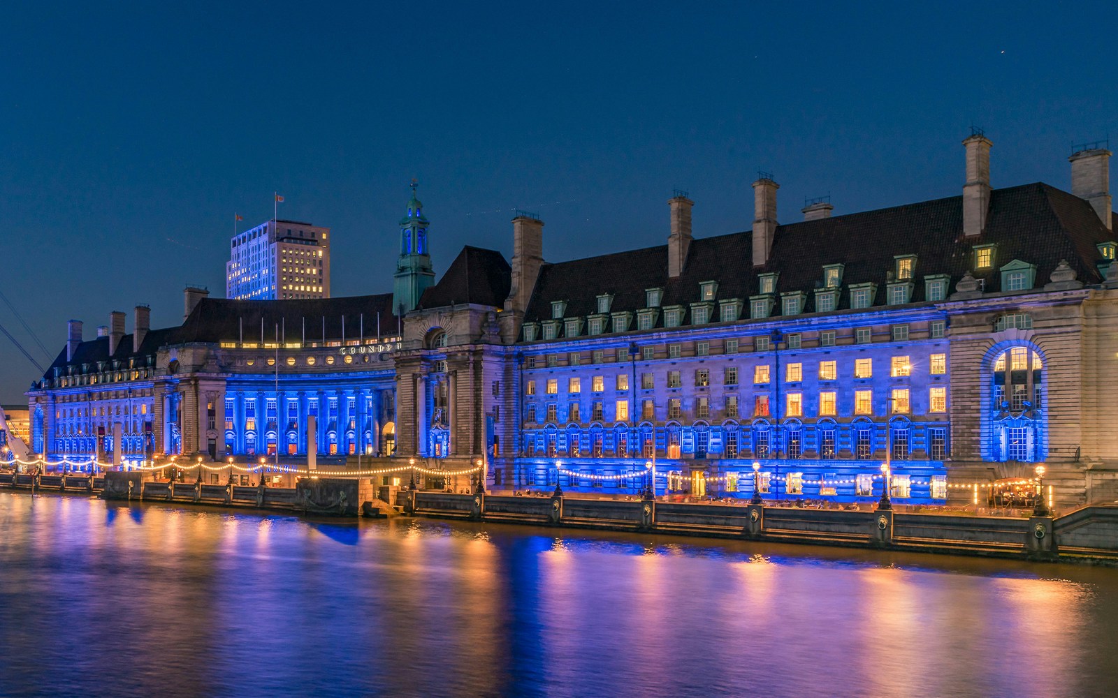 London Marriott Hotel County Hall illuminated at night along the River Thames.