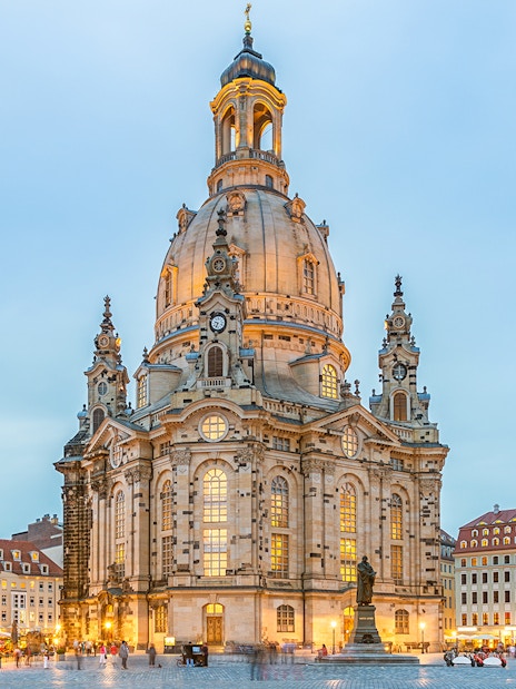 Frauenkirche in Dresden with illuminated dome and surrounding square at dusk.