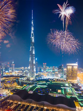 Burj Khalifa with fireworks in Dubai skyline at night.