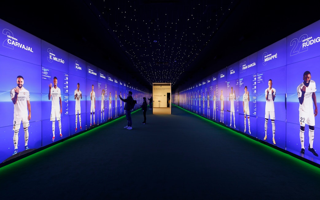 Visitors interacting with digital displays in the audiovisual room at Santiago Bernabéu Stadium.