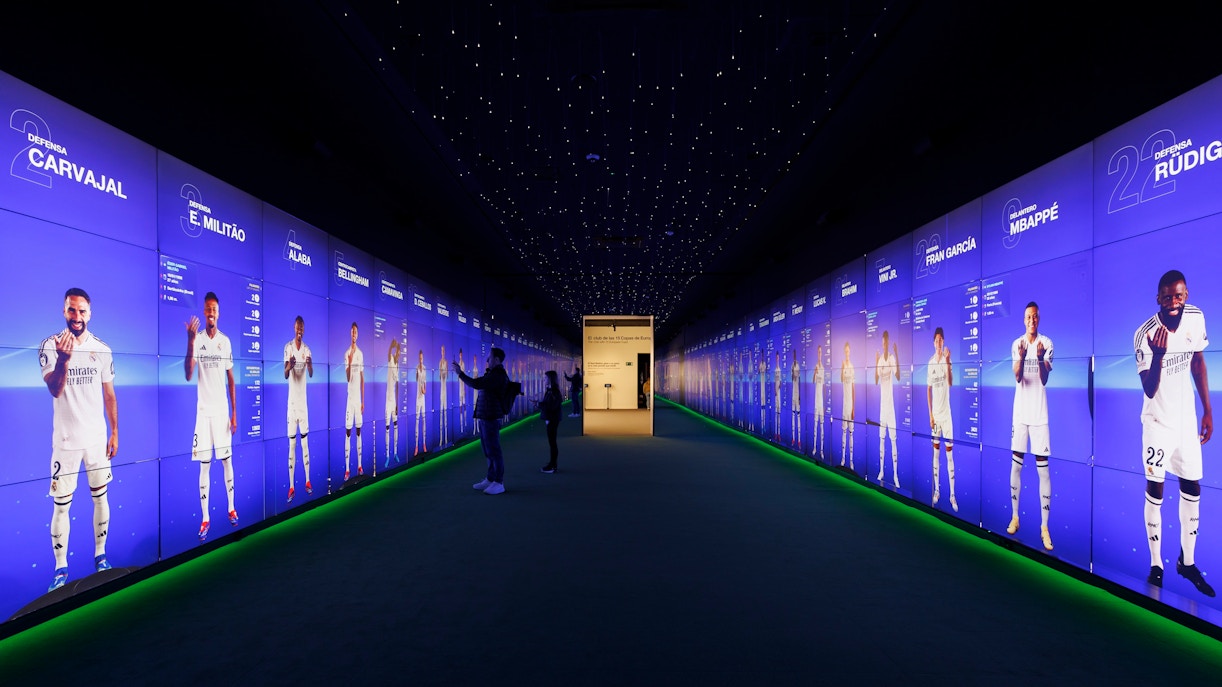 Visitors interacting with digital displays in the audiovisual room at Santiago Bernabéu Stadium.