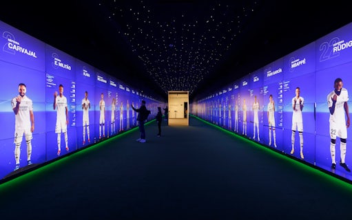 Visitors interacting with digital displays in the audiovisual room at Santiago Bernabéu Stadium.