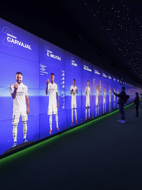 Visitors interacting with digital displays in the audiovisual room at Santiago Bernabéu Stadium.