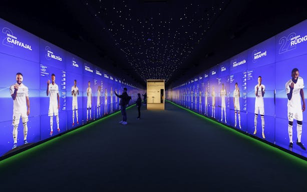 Visitors interacting with digital displays in the audiovisual room at Santiago Bernabéu Stadium.