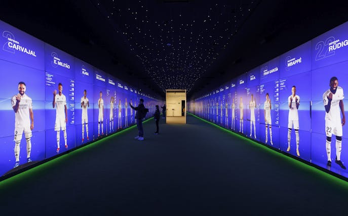 Visitors interacting with digital displays in the audiovisual room at Santiago Bernabéu Stadium.