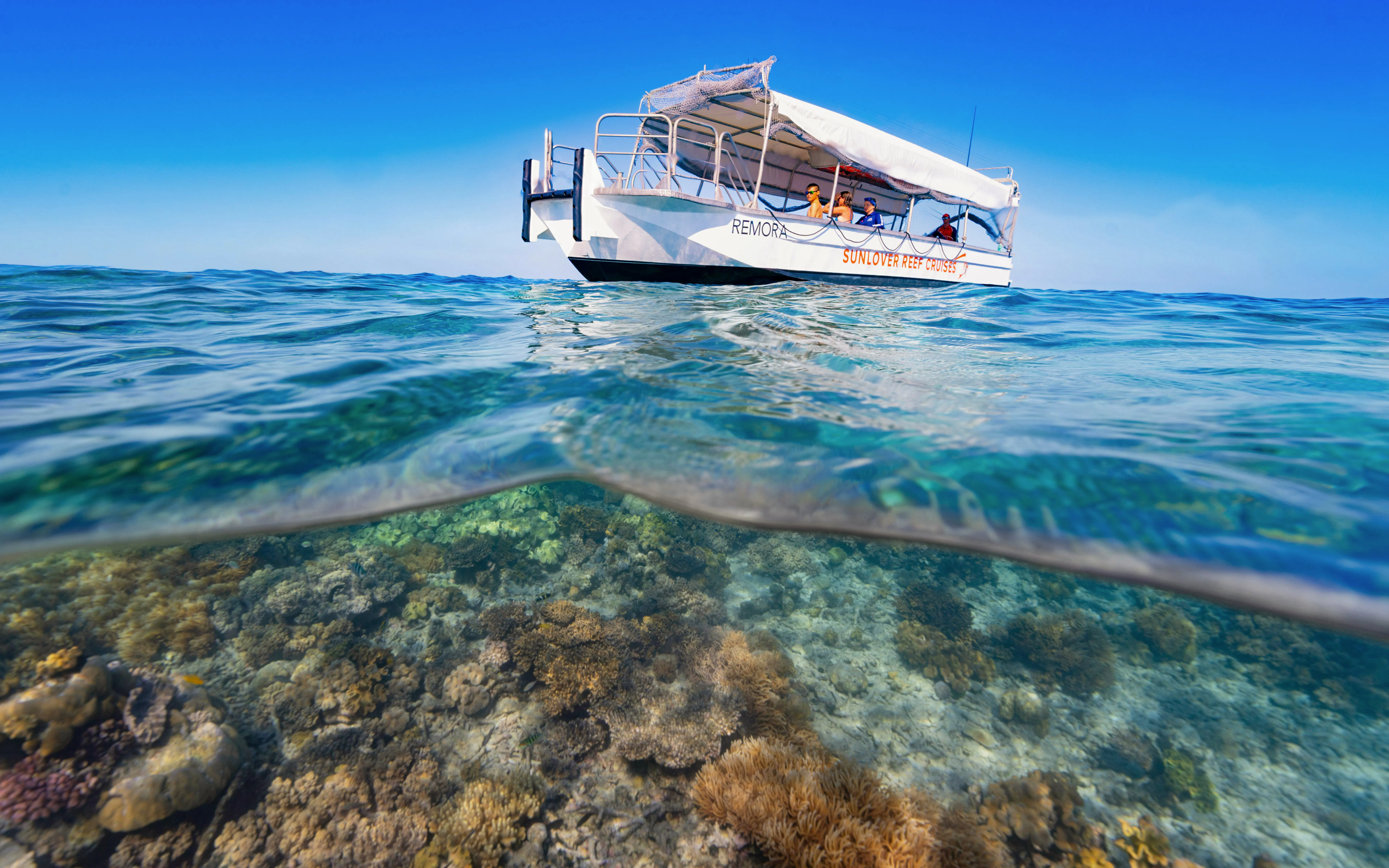 Sunlover Reef Cruises boat above coral reef at Great Barrier Reef.