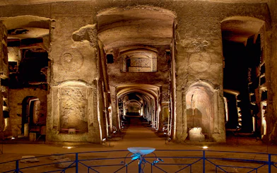 Catacombs of San Gennaro, ancient underground burial site with illuminated arches and passageways.