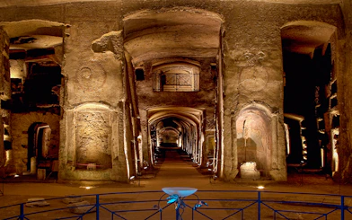 Catacombs of San Gennaro, ancient underground burial site with illuminated arches and passageways.