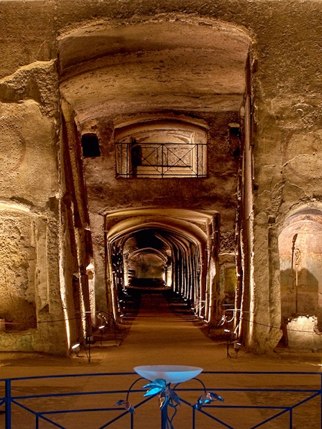 Catacombs of San Gennaro, ancient underground burial site with illuminated arches and passageways.