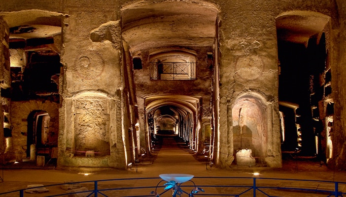 Guided tour inside the Catacombs of San Gennaro, Naples, showcasing ancient frescoes and burial sites.