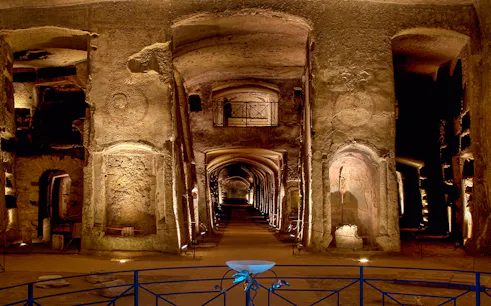 Catacombs of San Gennaro, ancient underground burial site with illuminated arches and passageways.