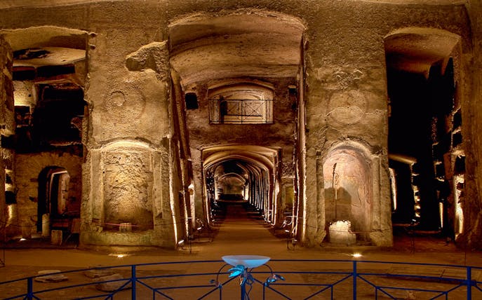Catacombs of San Gennaro, ancient underground burial site with illuminated arches and passageways.