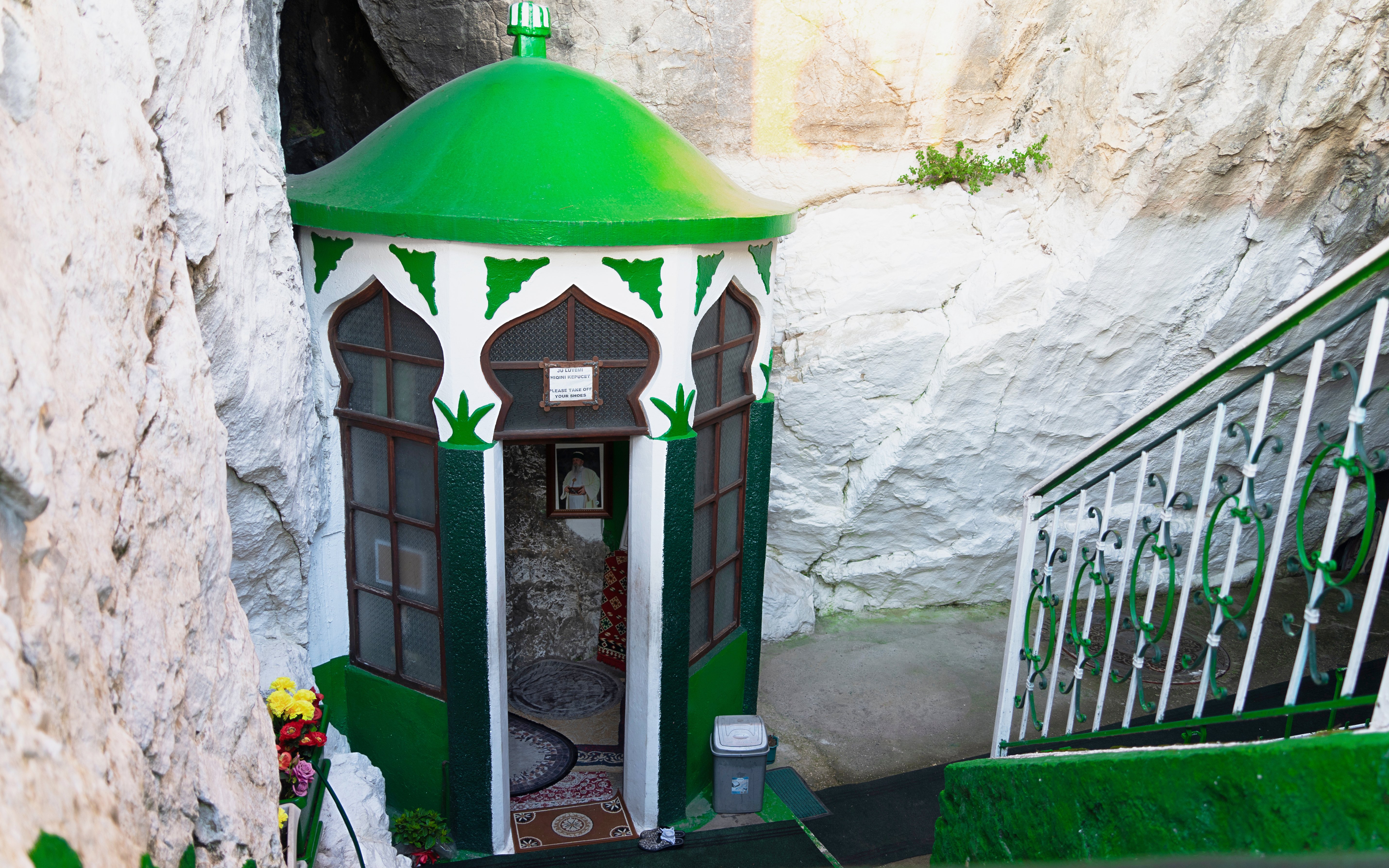 Sari Salltik shrine entrance in Kruja mountain, Albania, with green dome and floral decorations.