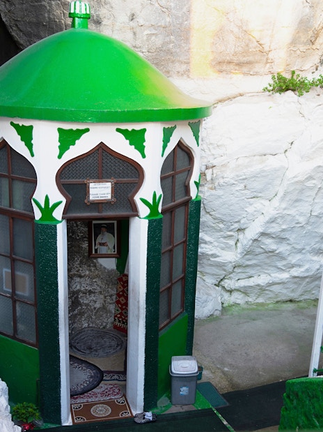 Sari Salltik shrine entrance in Kruja mountain, Albania, with green dome and floral decorations.