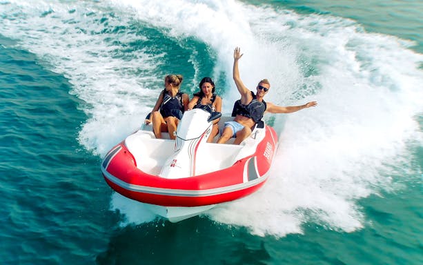 Tourists enjoying a ride on a self-drive boat in open water.