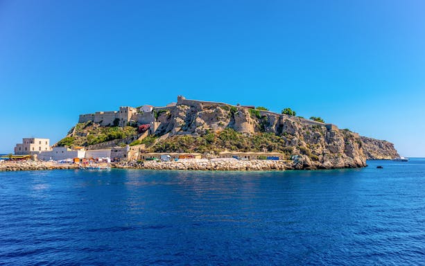 Ferry approaching Tremiti Islands' rocky coastline from Rodi Garganico.