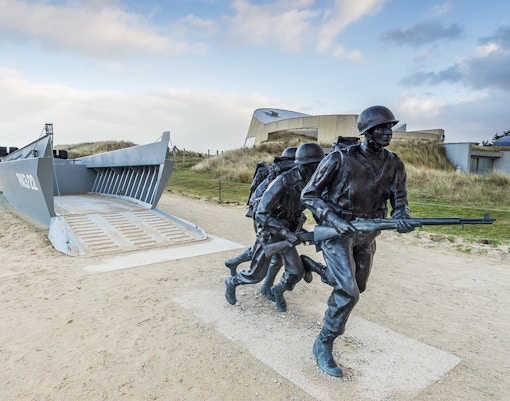 Normandy D-Day Tour visitors exploring Omaha Beach memorial site in France.