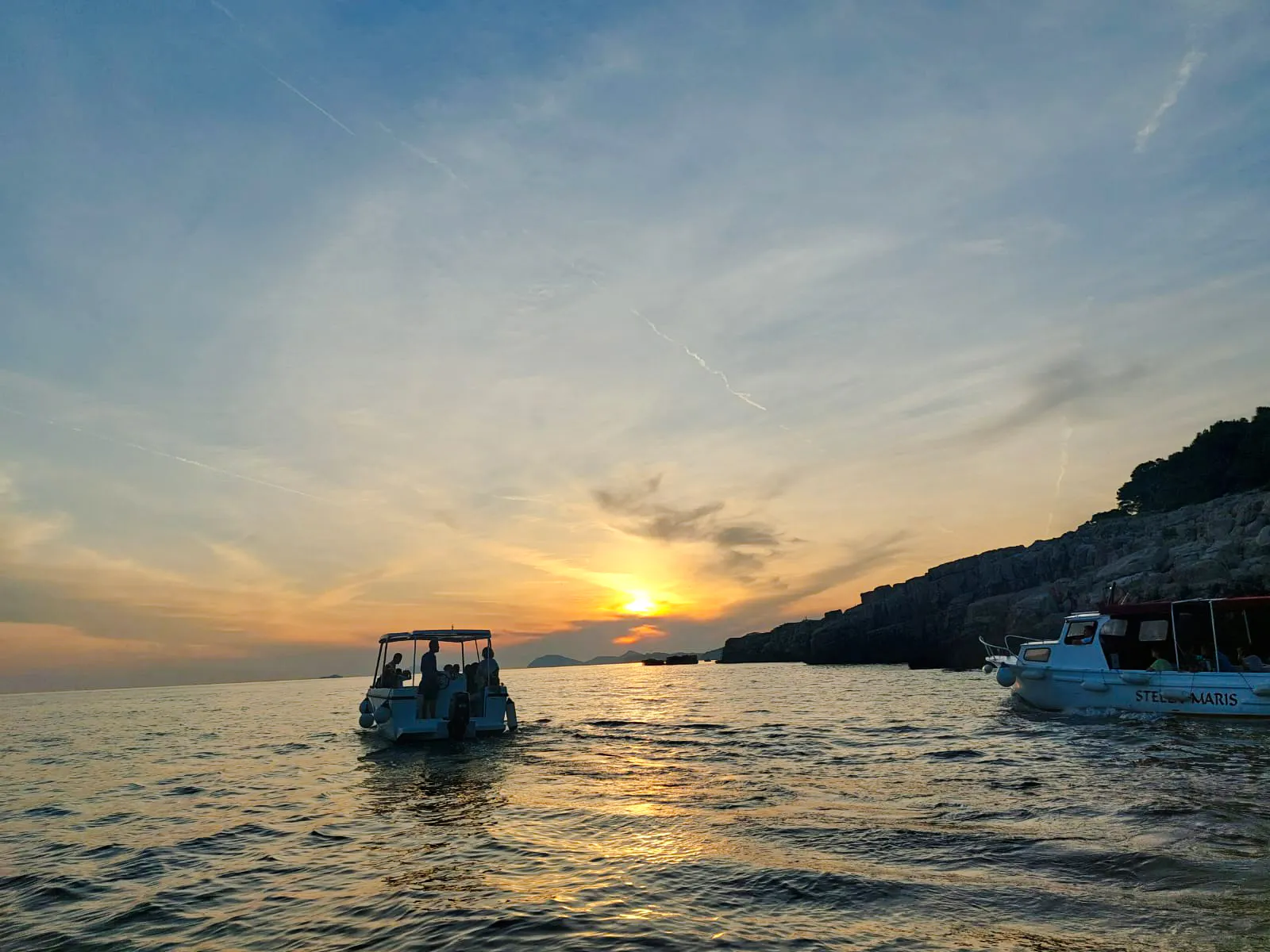 Boat tour at sunset near Dubrovnik coastline, part of History Walk & Dubrovnik Panorama by Boat.