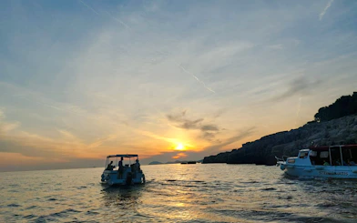 Boat tour at sunset near Dubrovnik coastline, part of History Walk & Dubrovnik Panorama by Boat.