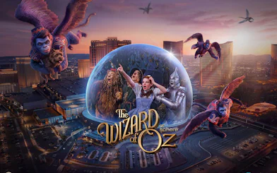 Wizard of Oz characters in a dome with flying monkeys over a cityscape backdrop