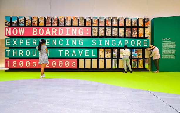 Visitors exploring exhibits at the National Museum of Singapore, showcasing travel experiences from the 1800s to 2000s.
