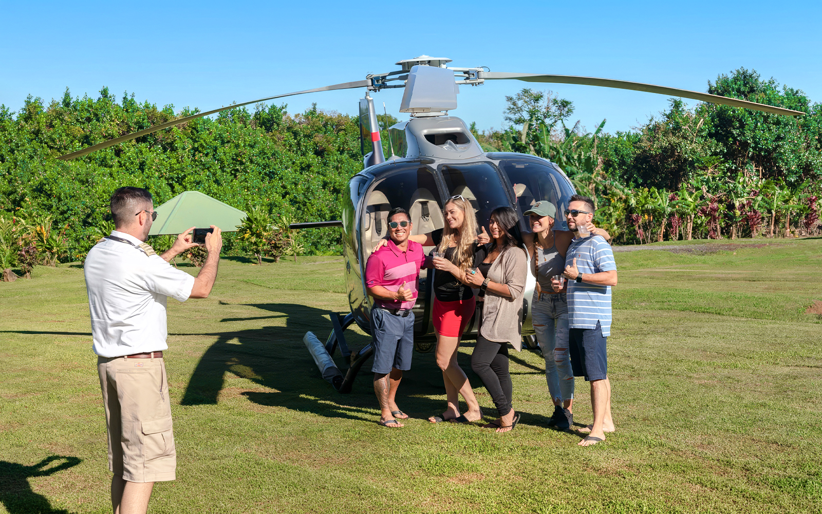 Group posing by helicopter on Hana Rainforest tour, Hawaii.